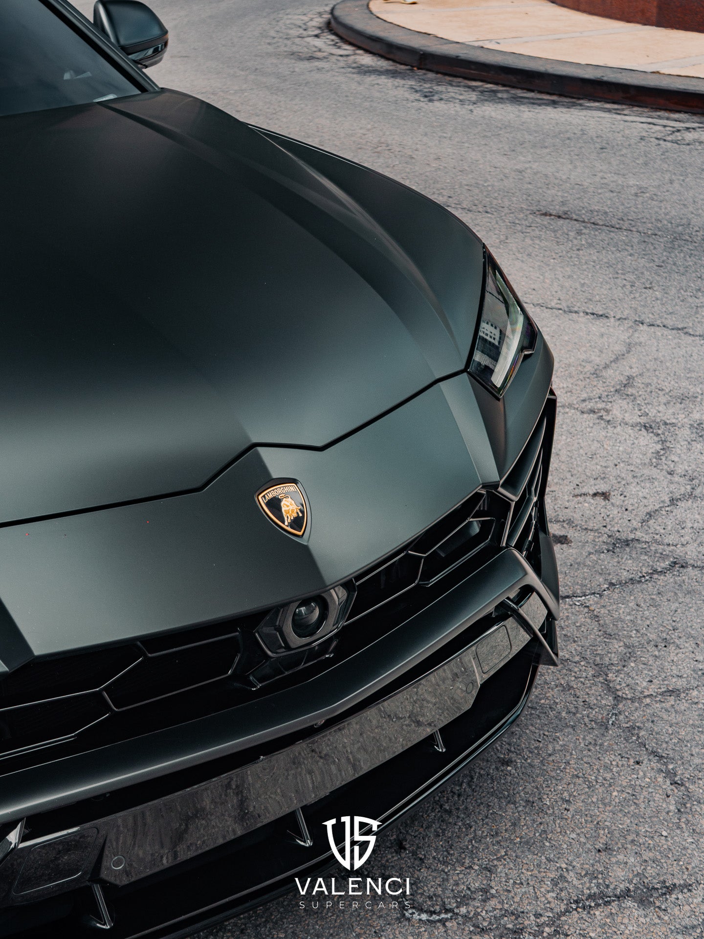 Lamborghini Urus close-up of the bold black grille featuring the iconic Lamborghini logo, showcasing its aggressive and luxurious SUV design.
