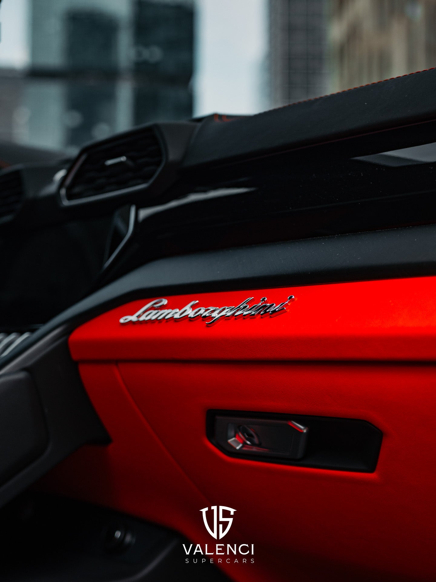 Lamborghini Urus close-up of the interior glove box featuring the iconic Lamborghini logo, showcasing luxurious craftsmanship and premium design.